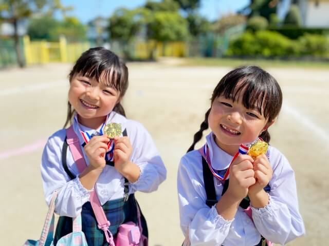メダルを手に持つ女の子二人